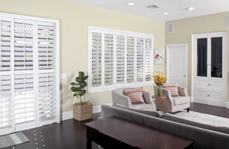 Living room with dark wood floors and white plantation shutters
